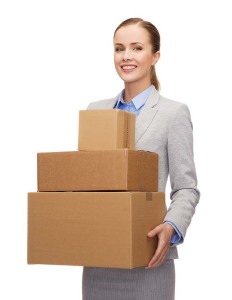smiling businesswoman holding cardboard boxes